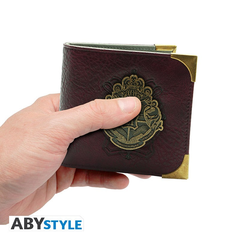 Hand houdt Harry Potter premium portemonnee vast aan de voorkant met Hogwarts embleem